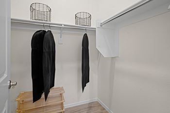 A closet with wooden steps and a black jacket hanging on the wall